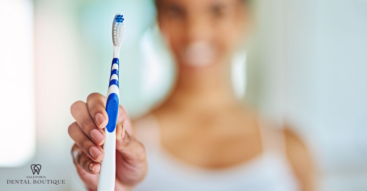 Person gently brushing teeth with a soft-bristled toothbrush after wisdom tooth extraction.