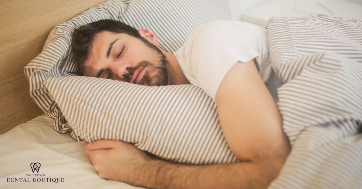 Person resting in bed with head elevated on pillows after wisdom tooth extraction