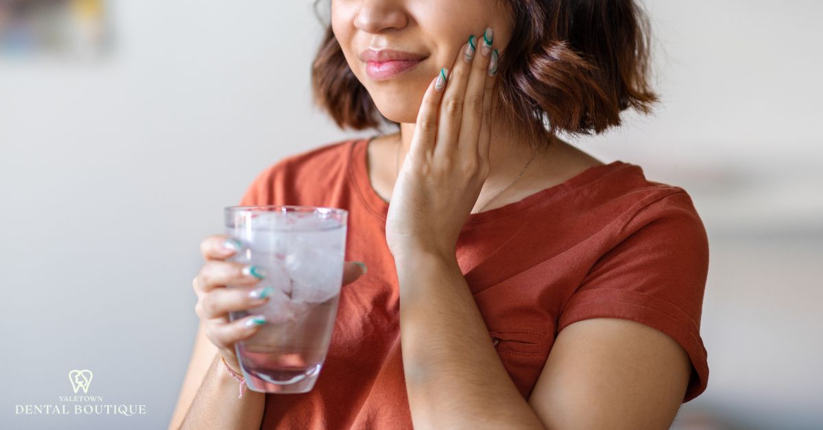A patient reacting to tooth sensitivity when drinking cold water after a dental filling.