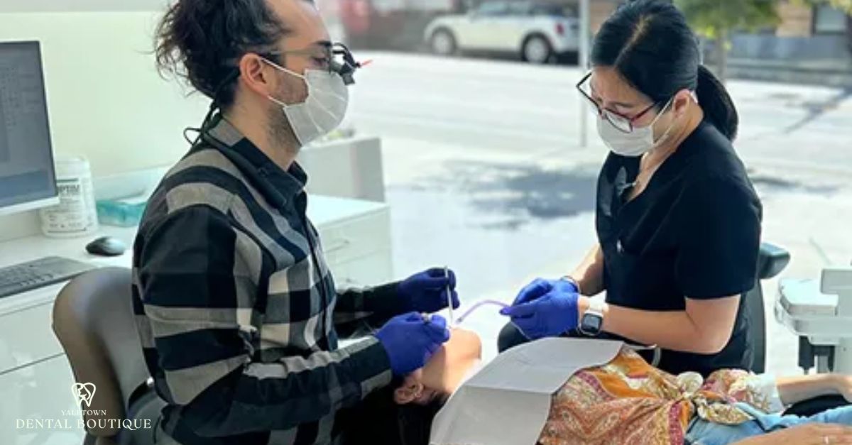 Dentists examining a patient’s mouth in preparation for getting a dental bridge treatment.