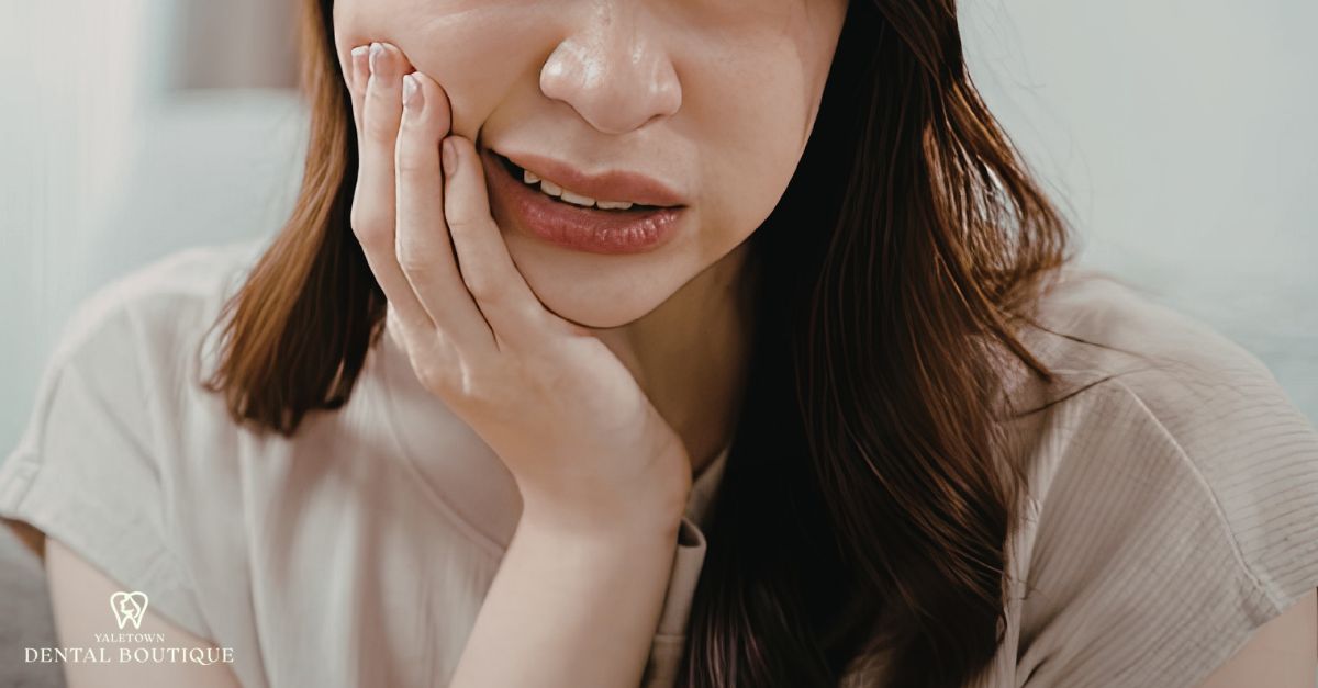 When a loose tooth is an emergency, a woman holds her jaw with visible discomfort and concern