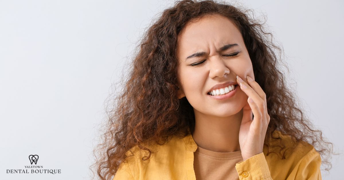 Signs that pain under a crown needs urgent care, with a patient experiencing persistent dental discomfort