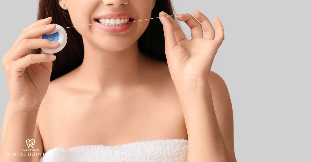 Flossing between teeth to help prevent side tooth cavities